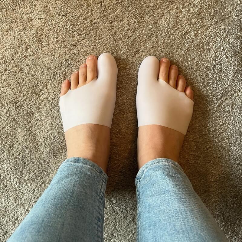 En kvinna som har Hallux valgus silikonstrumpa på båda fötterna sett ovanifrån
